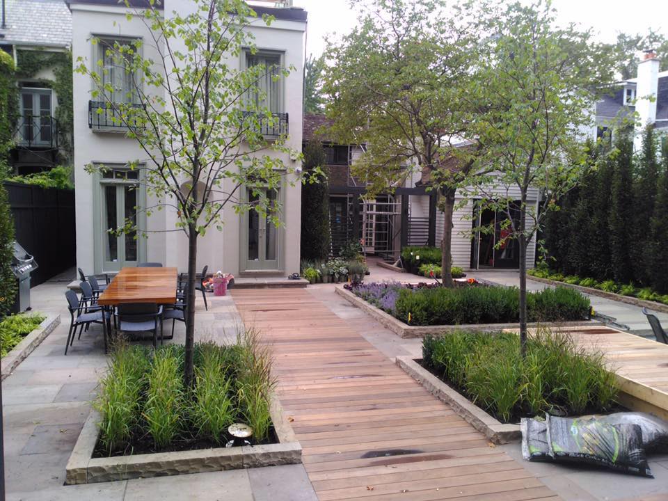 Contemporary backyard with wooden decking and integrated planters